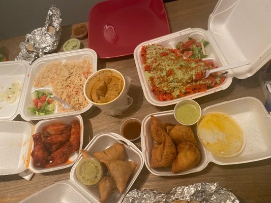 Full feast spread — samosas, wings, biryani, green sauce